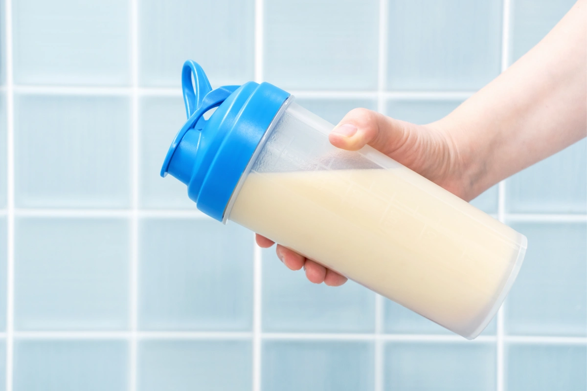 Mano sujeta un batido de proteína