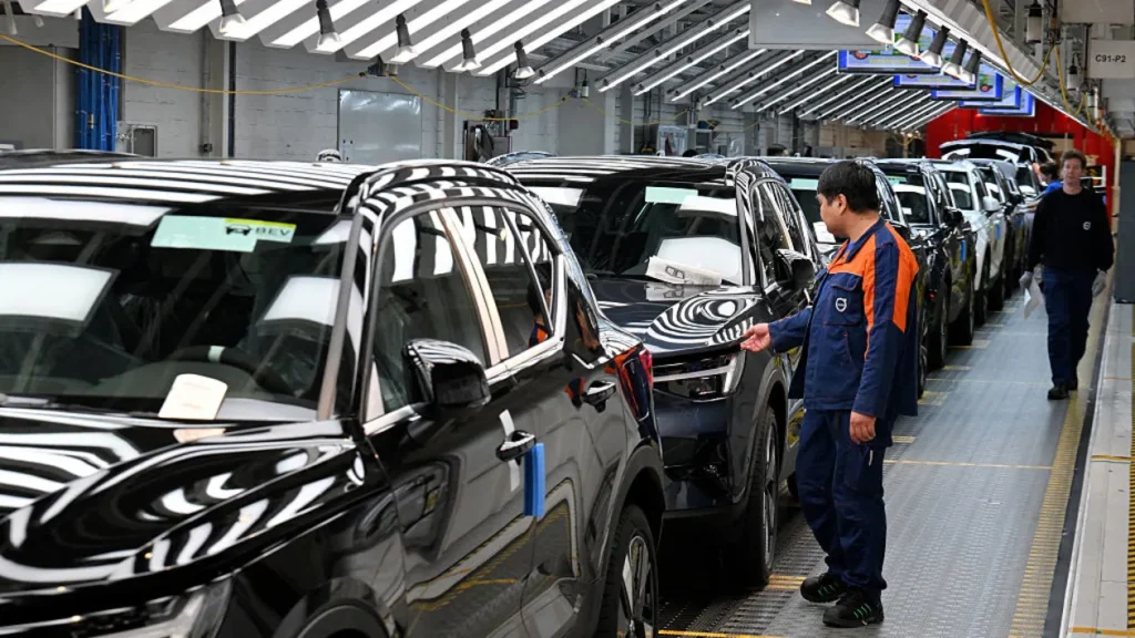 Os trabalhadores inspecionam carros no final da linha de produção da Volvo Factory em Ghent em 25 de abril de 2025.