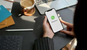 Mulher segurando celular com o Whatsapp