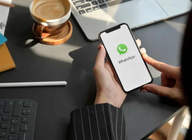 Mulher segurando celular com o Whatsapp