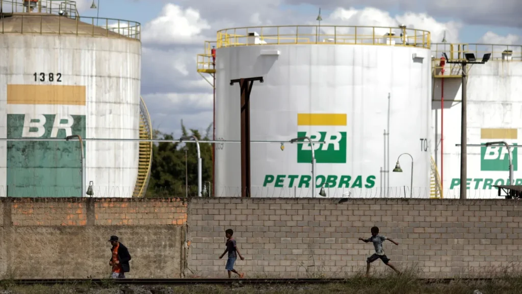 Pessoas andando em frente a uma usina da Petrobrás