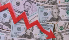 notas de dóalar com uma seta de indicador de queda