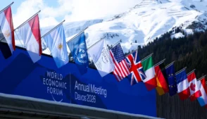 Bandeiras de vários países hasteadas sobre uma placa de Davos 2026