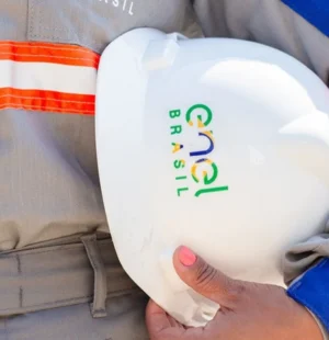 Pessoa segurando capacete com logo da Enel
