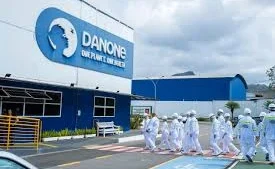 Imagem da fabrica da danone com seus funcionarios vestidos com trages de EPi