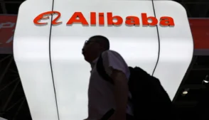 Pessoa passando em frente ao letreiro do Alibaba