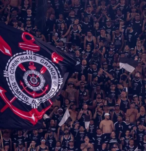 Torcedores do Corinthians em arquibancada com a bandeira do time