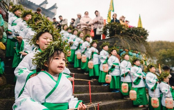 เด็กๆ ยืนอยู่ทั้งสองข้างหน้าประตูวัดเป็นพิธีเพื่อเฉลิมฉลองฤดูใบไม้ผลิที่หมู่บ้าน Miaoyuan มณฑลเจ้อเจียง เมื่อวันที่ 4 กุมภาพันธ์ 2024 [รูปภาพ: China.org.cn]