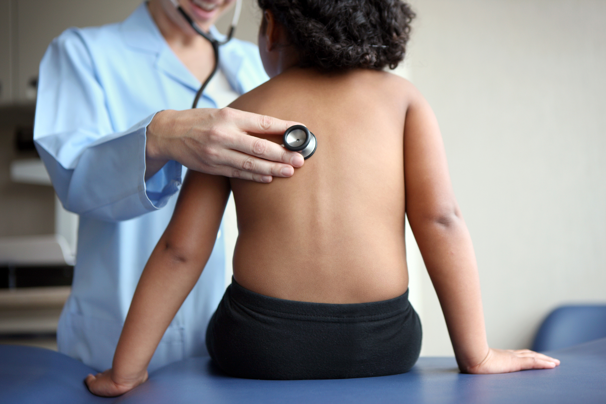 Doctor listens to girl's breathing.