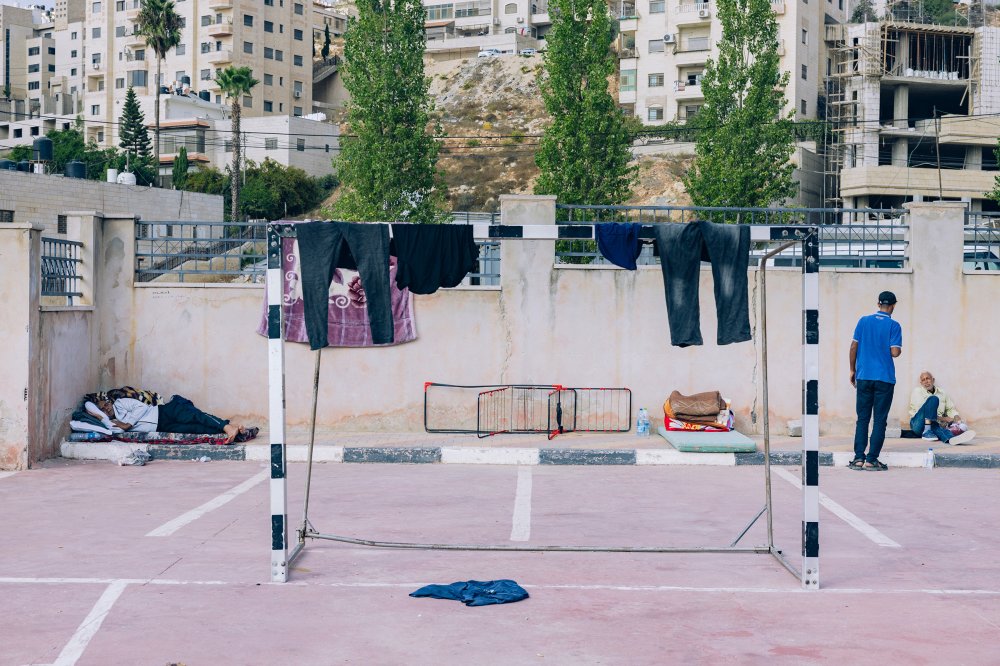 2023年10月14日,在拉马拉市红色体育俱乐部,加沙工人被困在以色列的衣服挂在足球门上晾干。