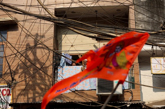 People look out of a balcony as a procession celebrating the upcoming Hindu Ram Temple in the northern town of Ayodhya passes by in the old quarters of Delhi, Jan. 16.