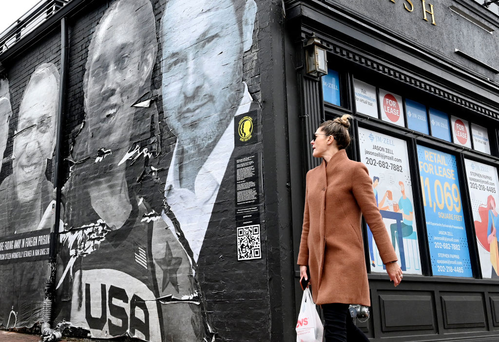 人们路过艺术家艾萨克·坎贝尔在乔治城创作的壁画，壁画中绘有美国女子篮球明星布兰妮·格里纳和在美国被拘留的其他美国人，这是“将我们的家人接回家”活动的一部分，活动地点在华盛顿特区。