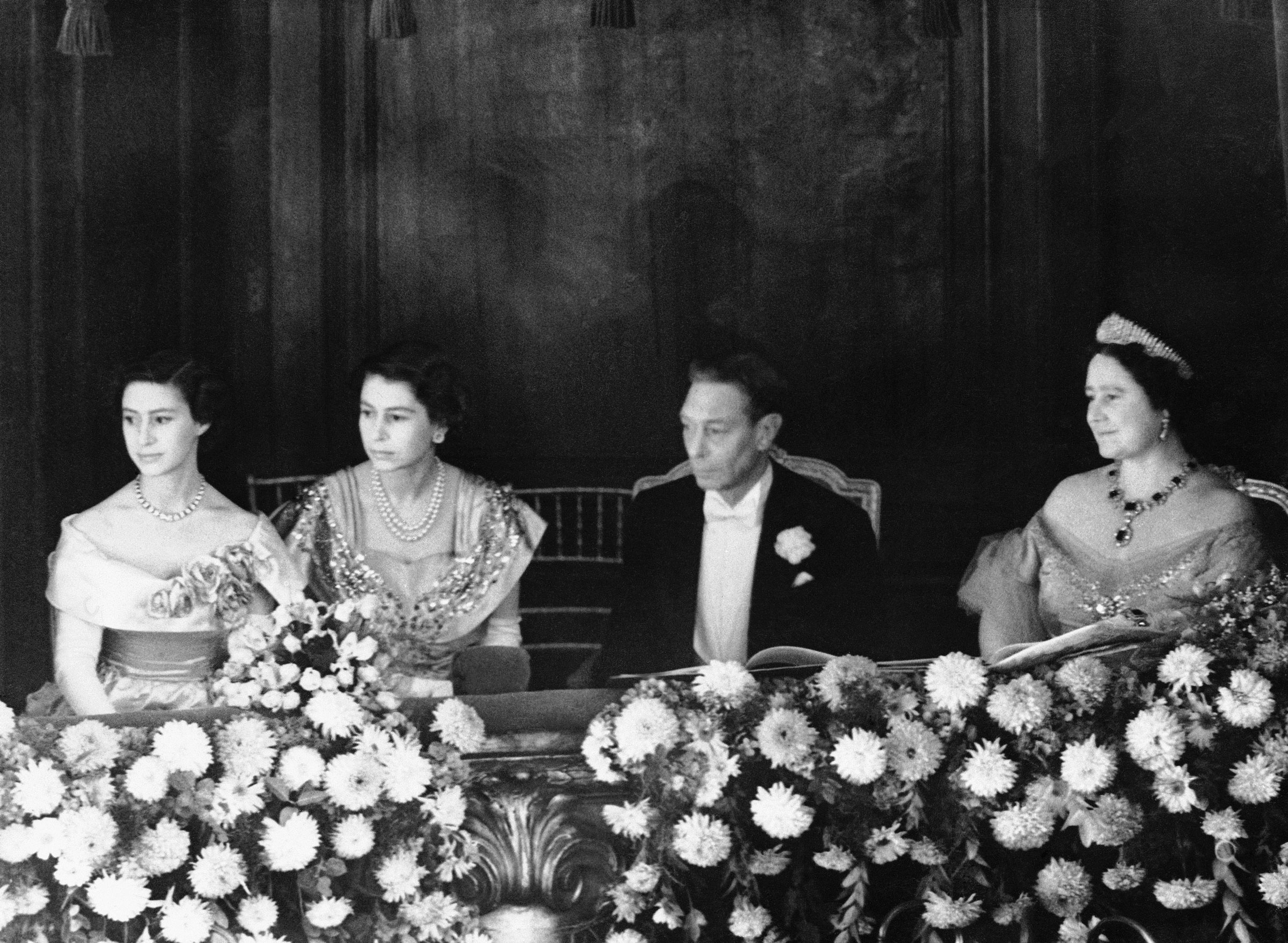 1950年11月13日，乔治六世国王和伊丽莎白王后与玛格丽特·罗斯公主和伊丽莎白公主坐在伦敦伦敦钯金剧院的包厢里。