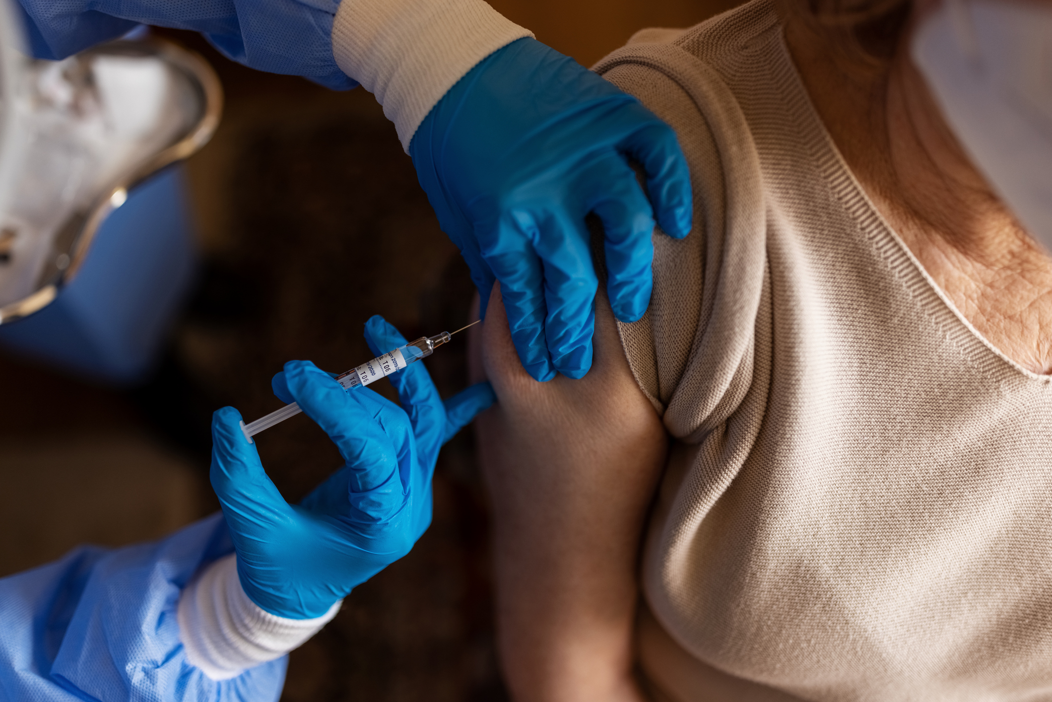 Senior female getting vaccinated at home