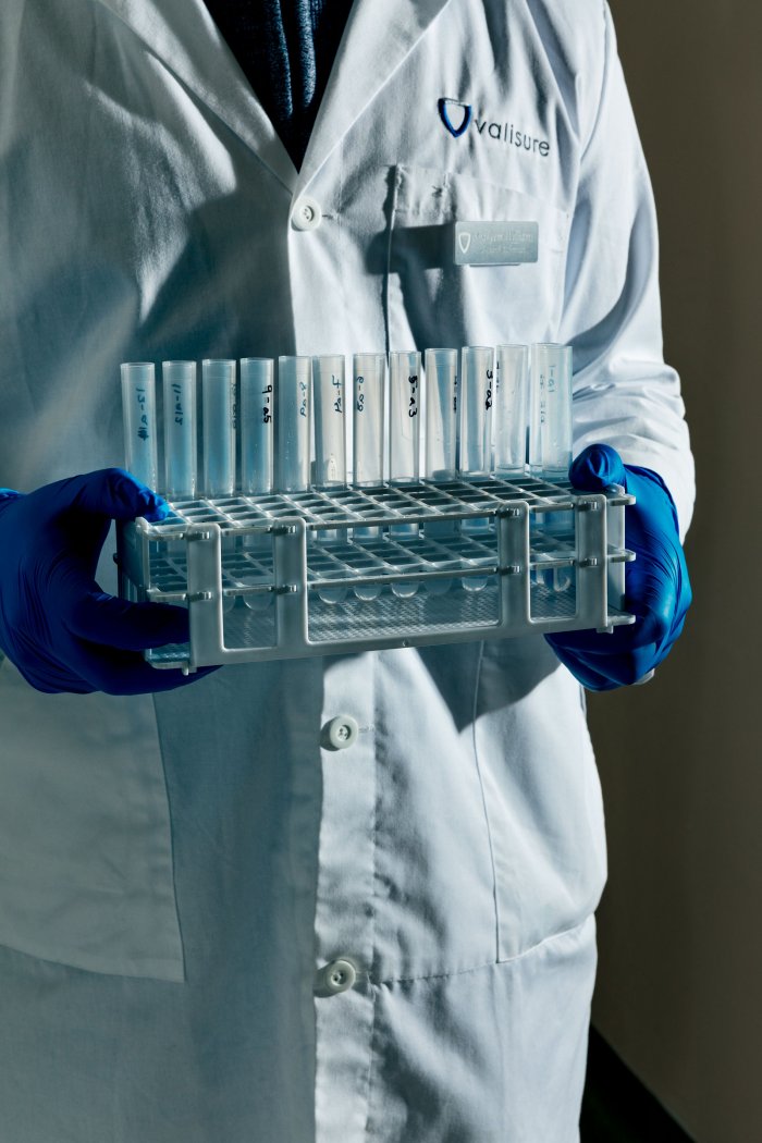 triptych of hands in blue gloves in the Valisure lab