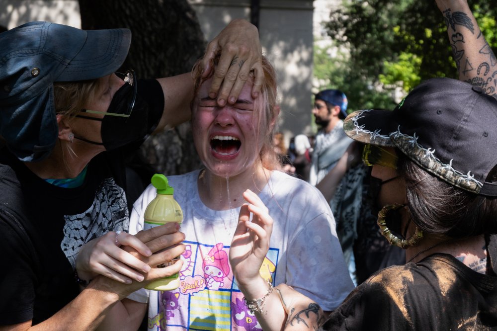 Pro-Palestine支持者在UCLA的Janss Steps上链接手臂,面对警察。