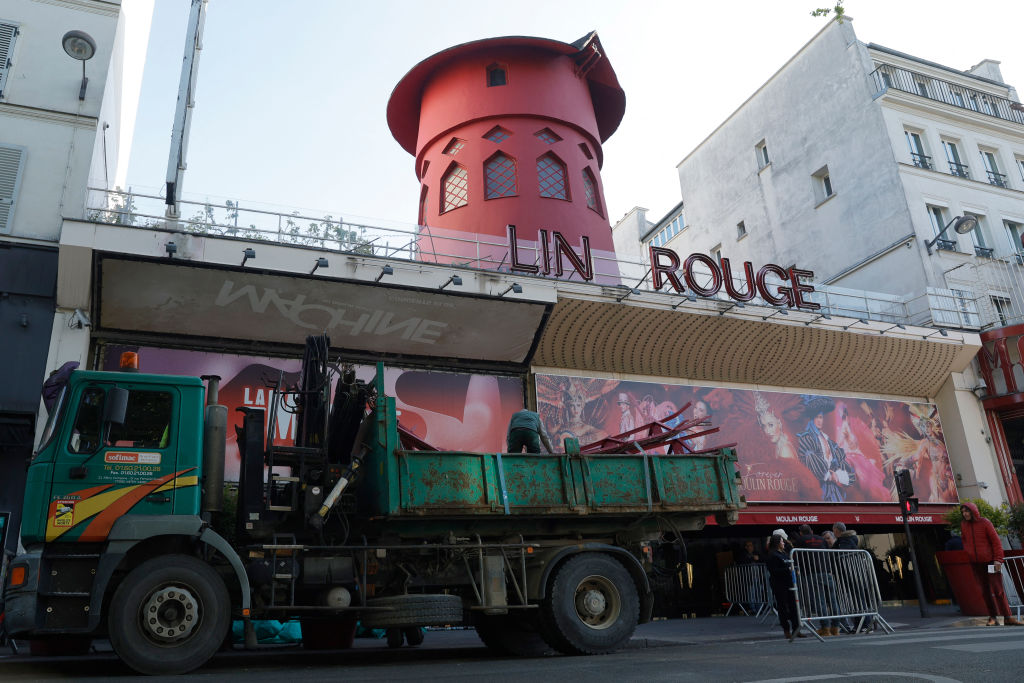 Arbeiter laden die Klingen der zusammengebrochenen Moulin Rouge Windmühle während der Nacht.