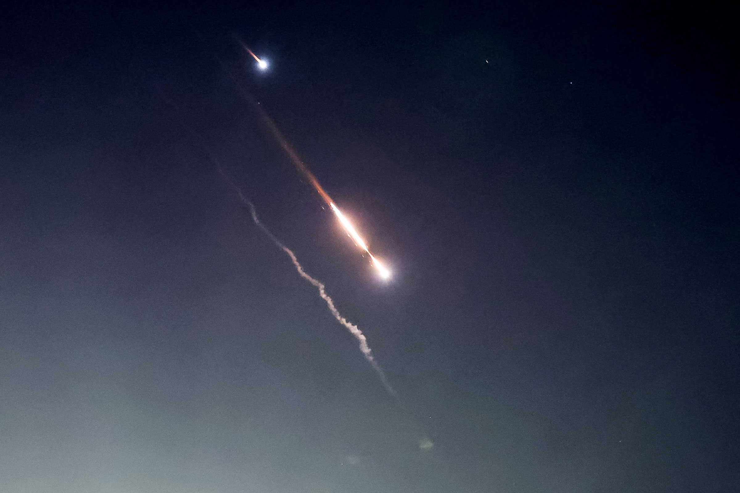 Objects are seen in the sky above Jerusalem after Iran launched drones and missiles towards Israel