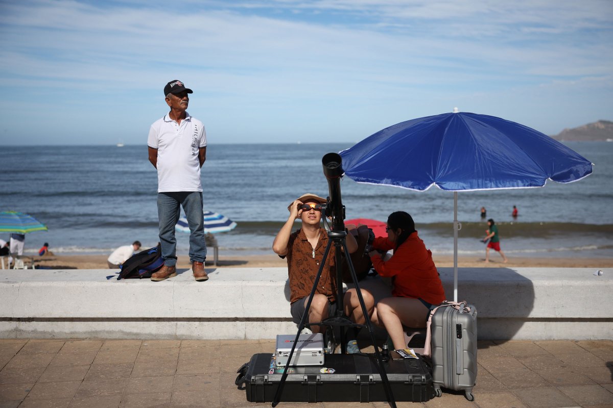 Menschen bereiten in Mazatlan, Mexiko, ihr Teleskop auf die Sonnenfinsternis vor.