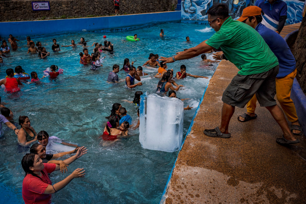 Arbeiter werfen Blöcke Eis in einen Pool angesichts extremer Hitze im Hidden Sanctuary Resort am 4. Mai 2024 in Marilao, Provinz Bulacan, Philippinen. 