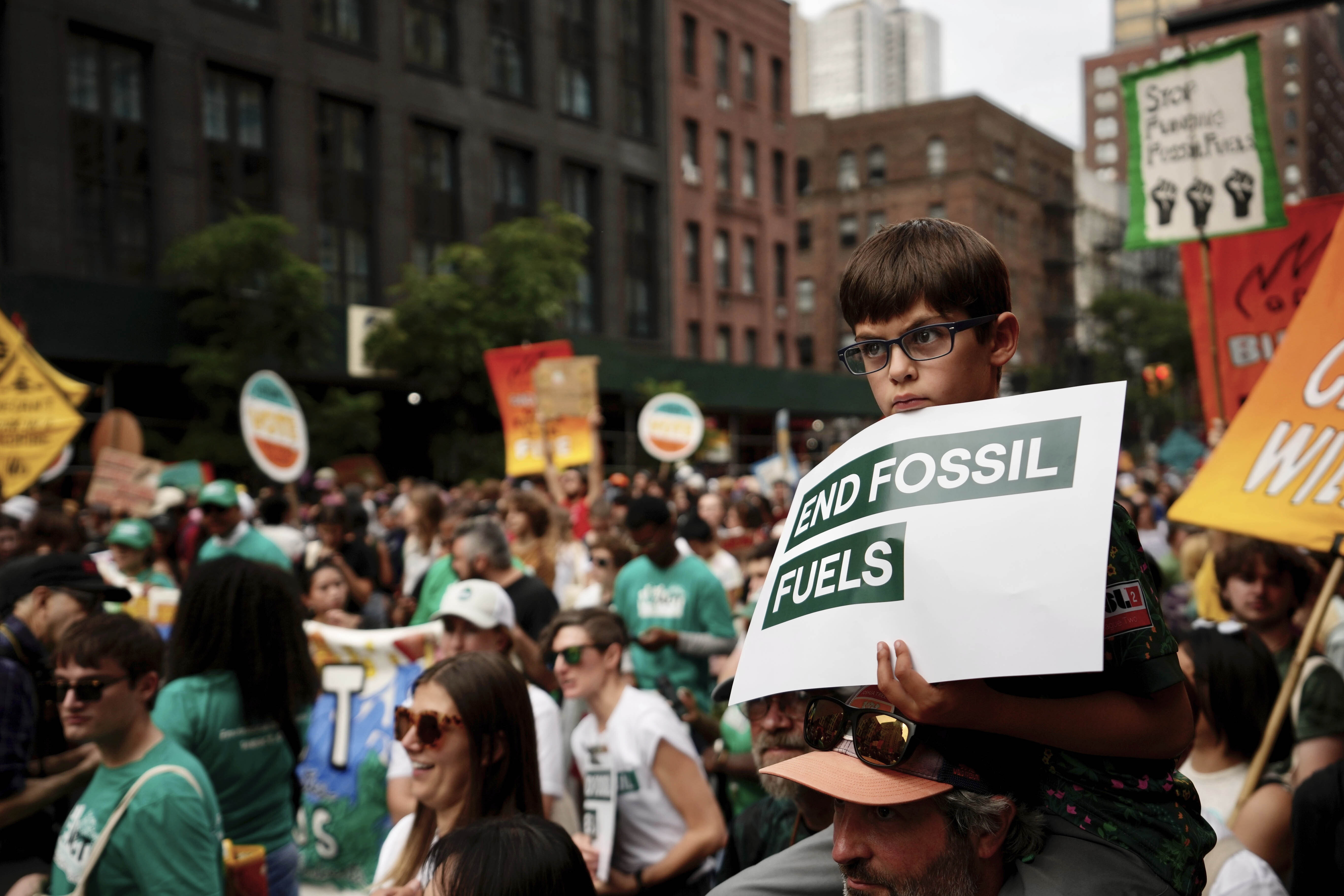 Oliver Moore, 7, of Montpelier, Vermont, listens to a speaker during a rally to end the use of fossil fuels, in New York, Sept. 17, 2023. 