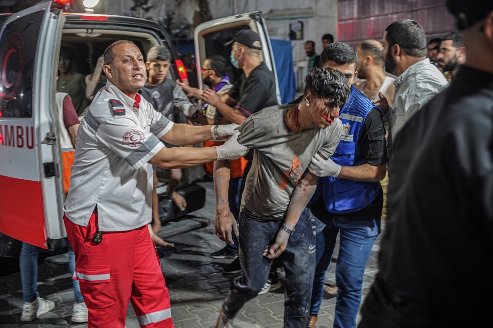 A paramedic catches an injured man at Al-Shifa hospital after retrieving him from the scene of the bombing, Oct. 9.