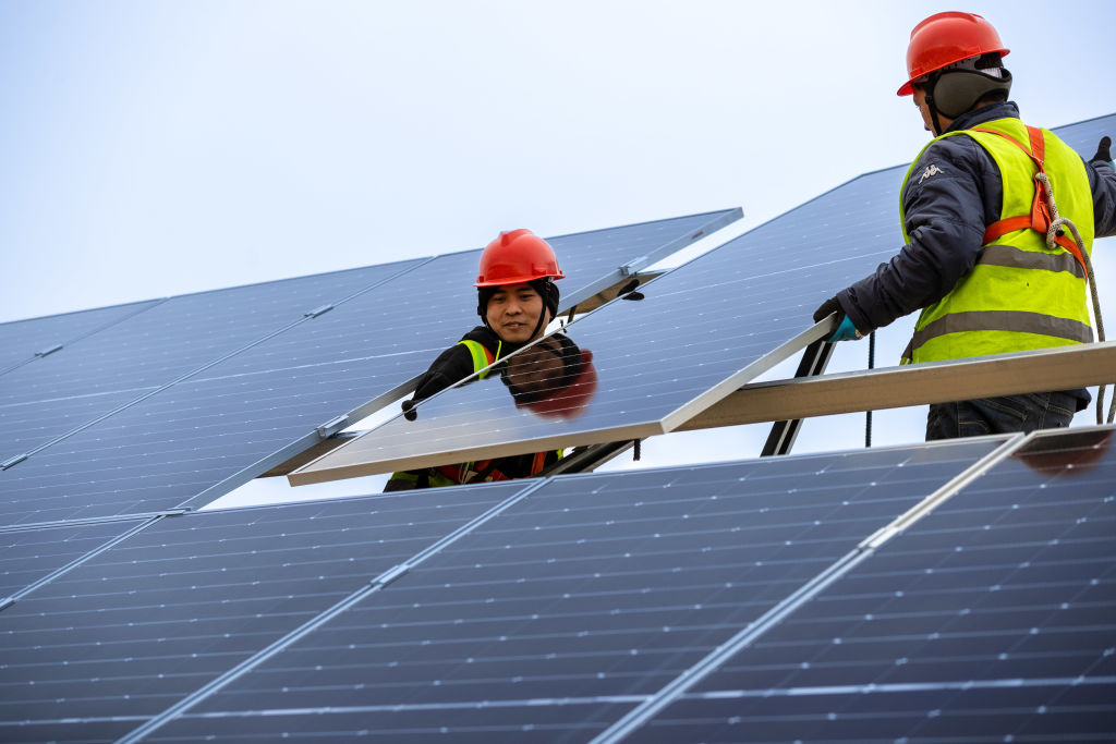 Workers install solar panels at the construction site of a 100MW solar photovoltaic power project on Feb. 21, 2023 in Ordos, Inner Mongolia Autonomous Region of China. 