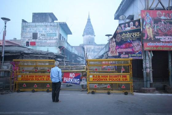 Isang lokal na lalaki ay tumingin sa pamamagitan ng barricade sa kalye malapit sa Hanmuna Gadhi temple sa Ayodhya noong Nobyembre 9, 2019, bago ang desisyon ng Kataas-taasang Hukuman tungkol sa hinaharap ng isang pinag-aalitan na relihiyosong lugar sa banal na lungsod.