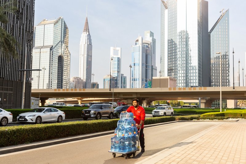 A man pushes a trolley with water in the center of Dubai on Dec. 13, 2023.