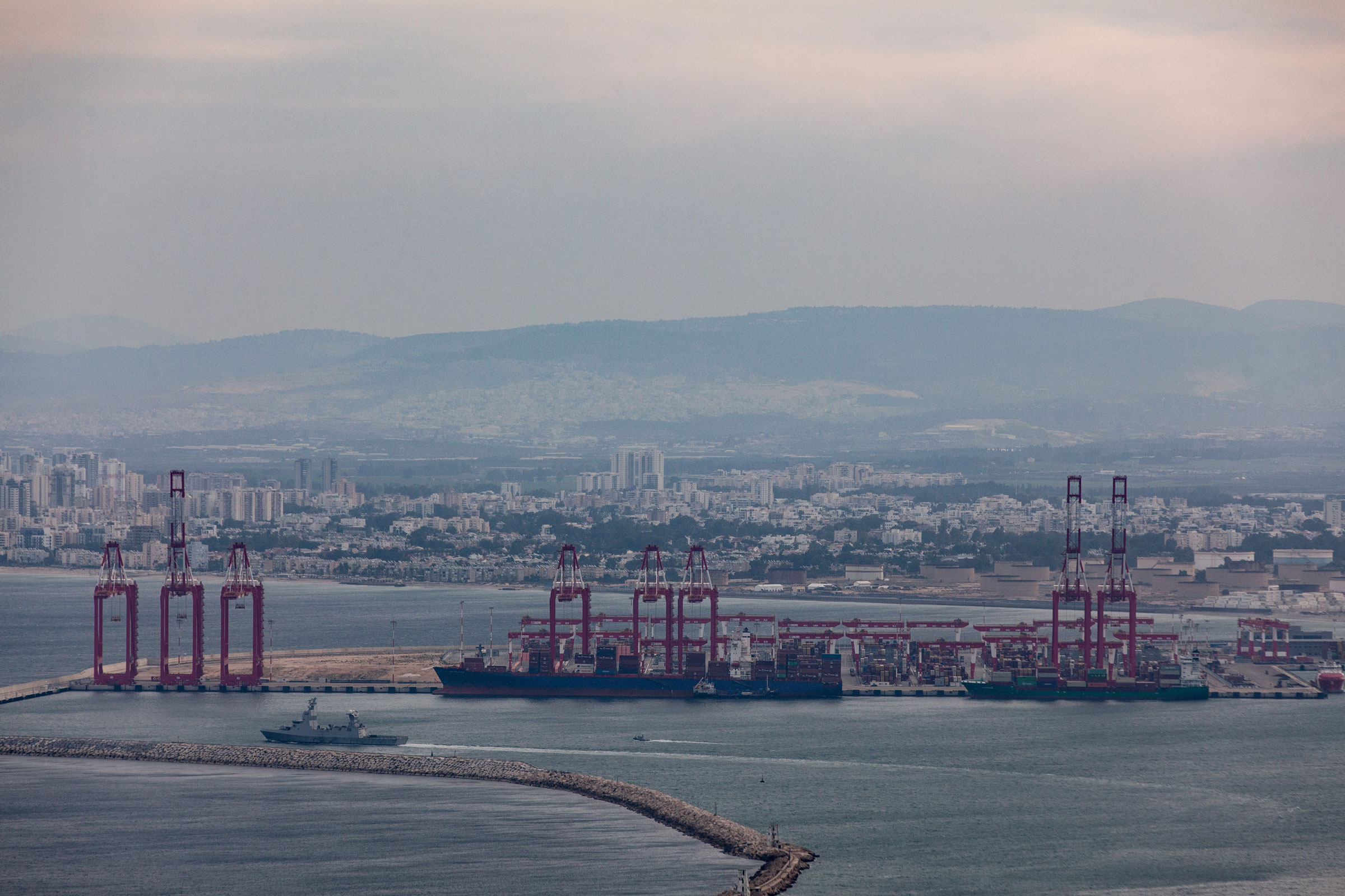 Commercial ships and an Israeli naval vessel are seen in the port city of Haifa