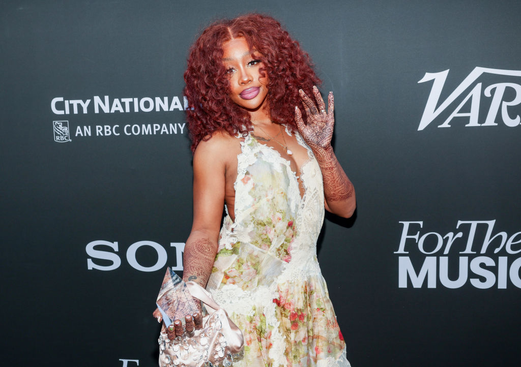 SZA waving on a red carpet