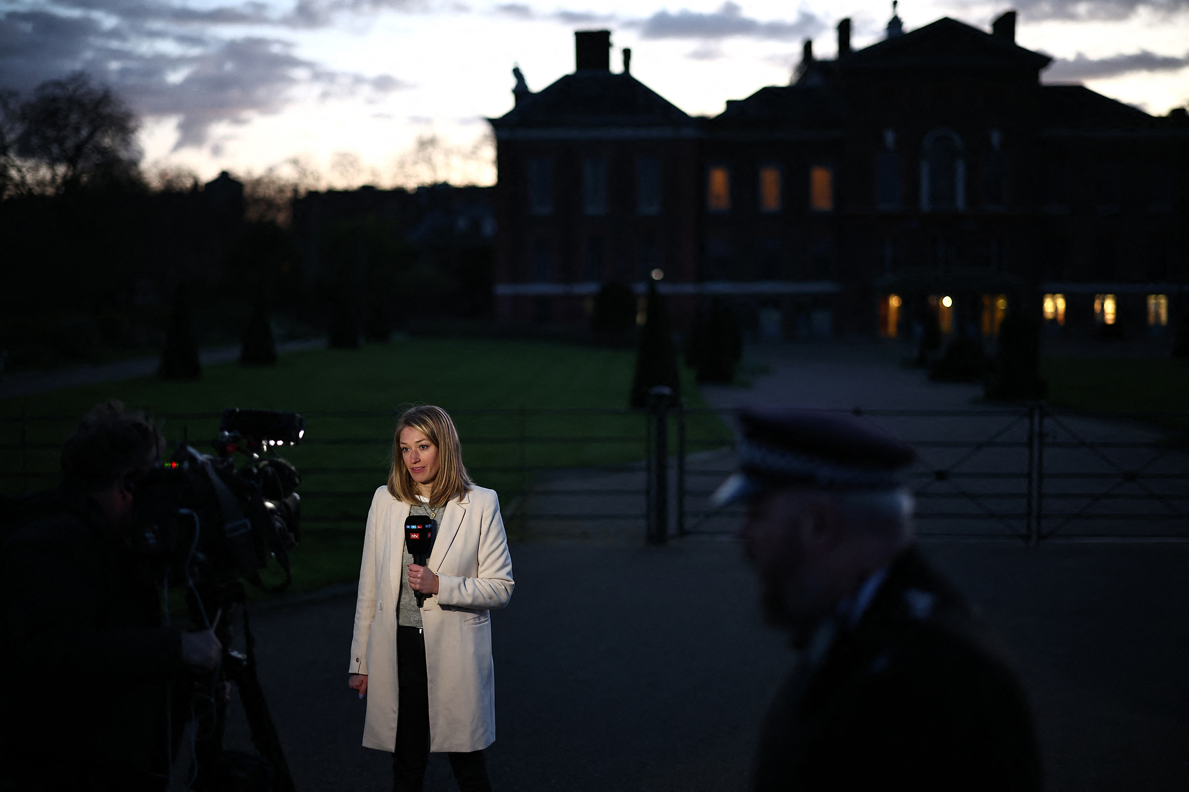 A journalist reports from outside Kensington Palace in London on March 22.