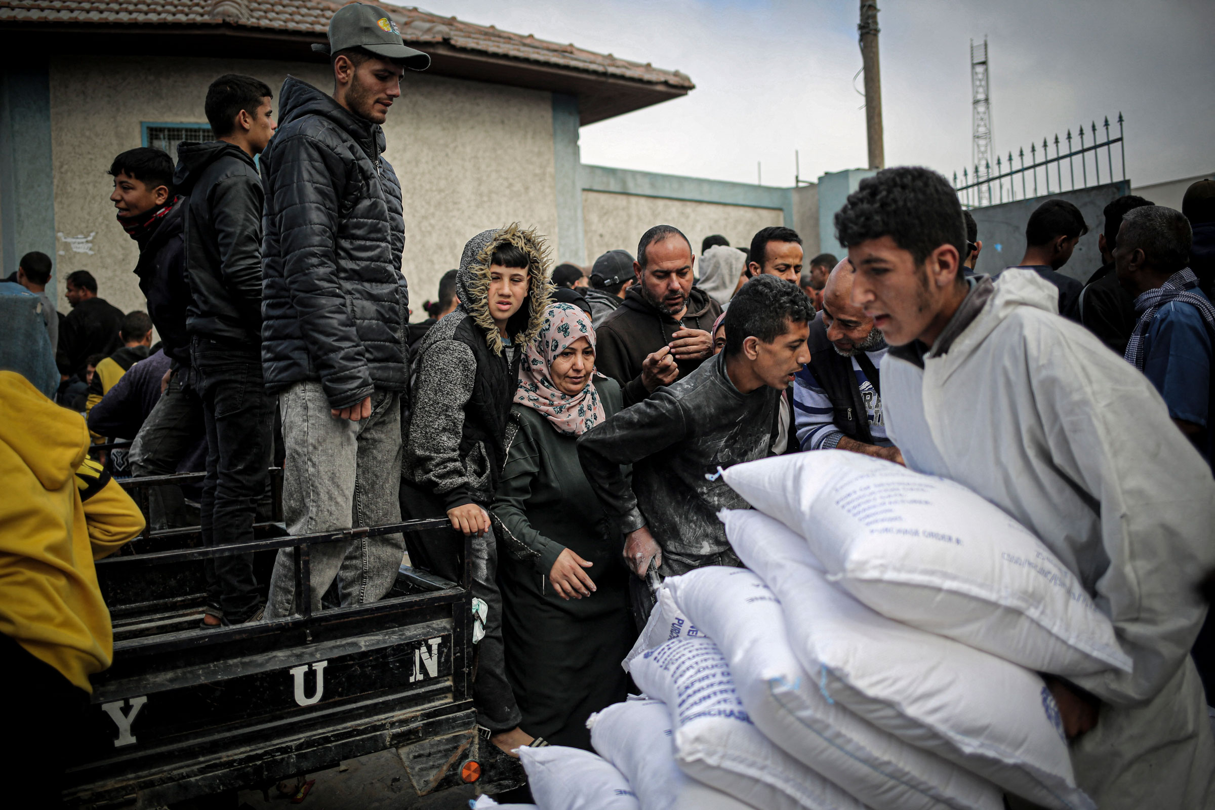 A Palestinian man transports sacks of humanitarian aid at the distribution center of the United Nations Relief and Works Agency for Palestine Refugees (UNRWA), in Rafah in the southern Gaza Strip, on March 3, 2024.