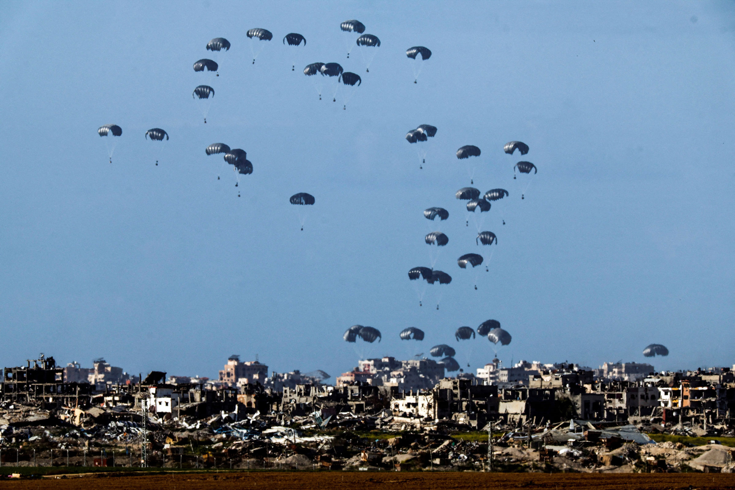 Packages fall towards northern Gaza, after being dropped from a military aircraft