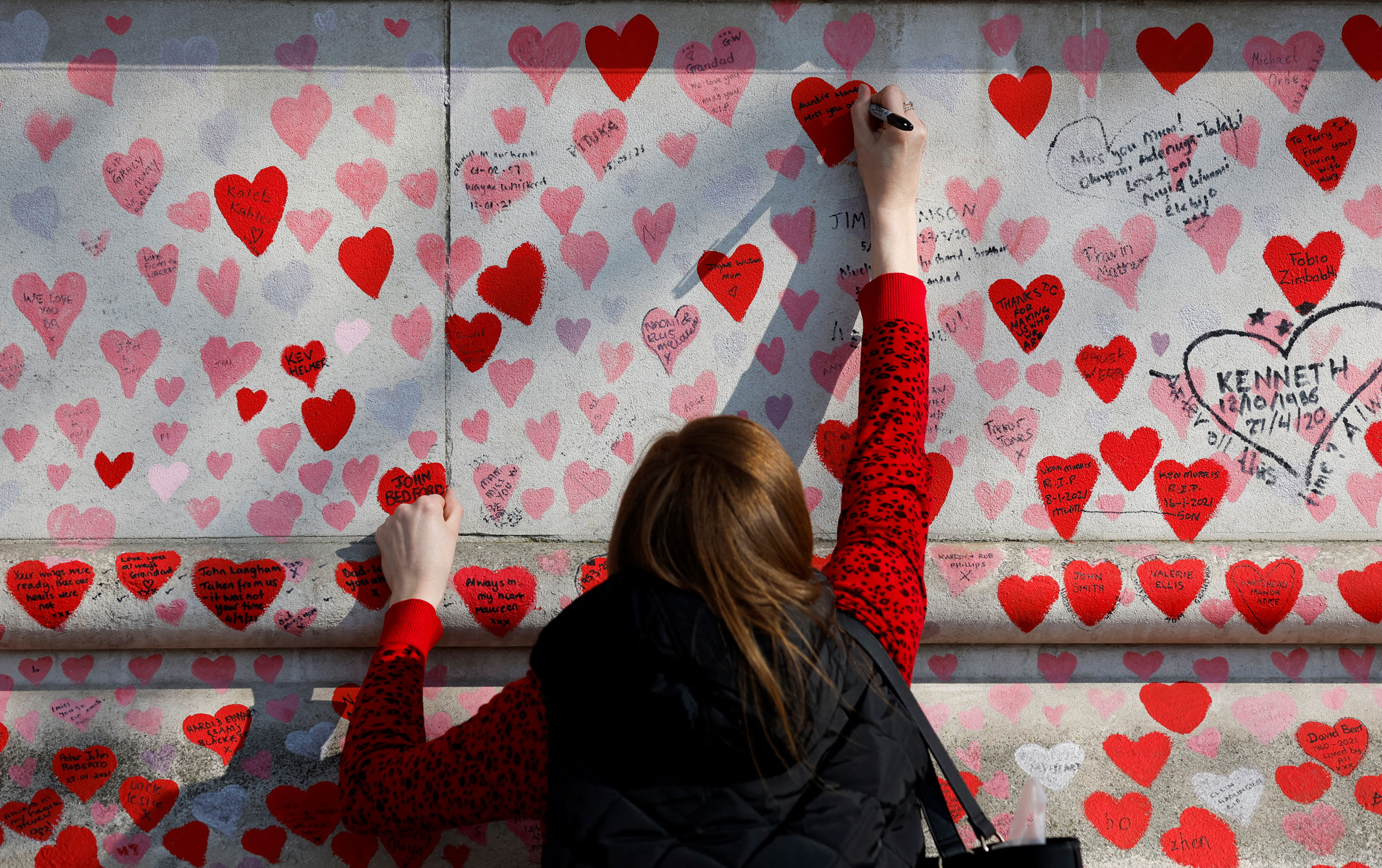 Isang tao sumusulat ng mensahe sa The National Covid Memorial Wall, sa araw ng pagpapahayag upang tandaan ang dalawang taon mula nang ang United Kingdom ay pumasok sa lockdown sa bansa, sa London, ika-23 ng Marso 2022.