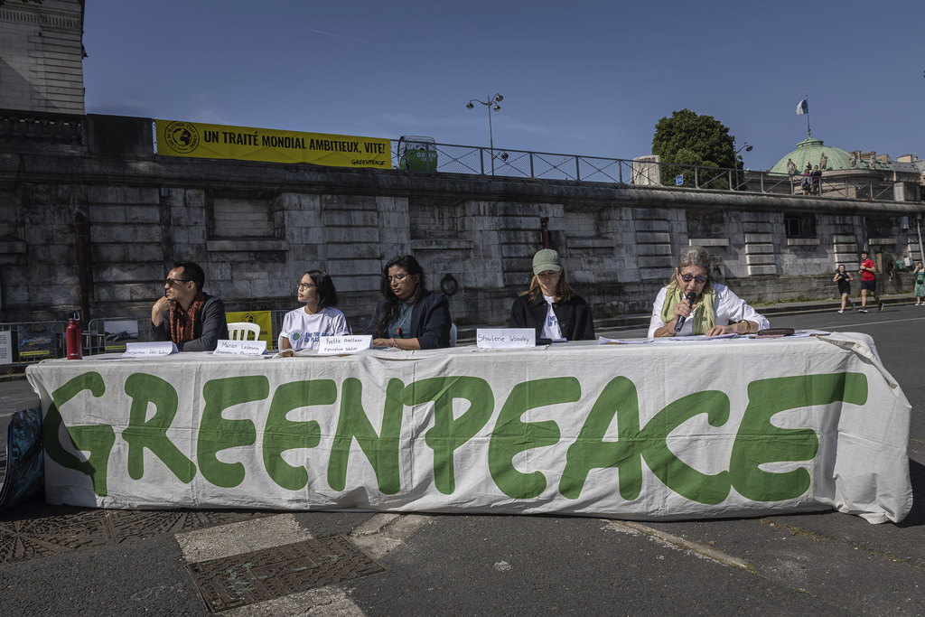 Members of Greenpeace press conference next to a giant art installation called 'Perpetual Plastic Machine' ahead of Global Plastic Treaty talks in Paris on May 27, 2023.