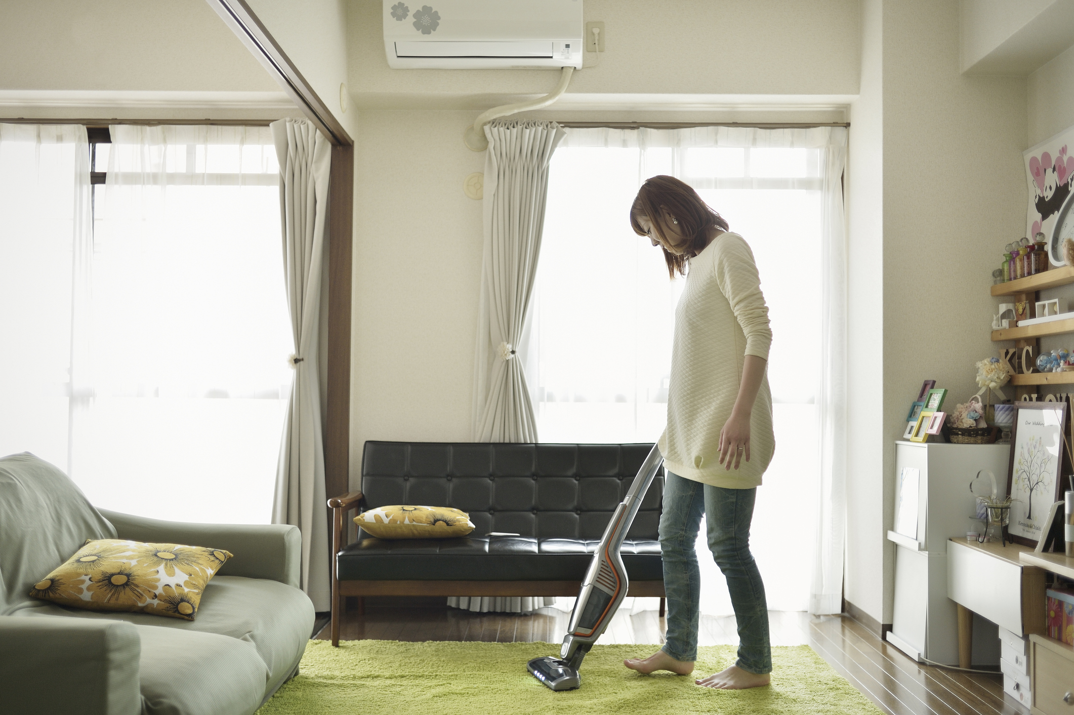 Eine Frau saugt den Raum mit einem Staubsauger