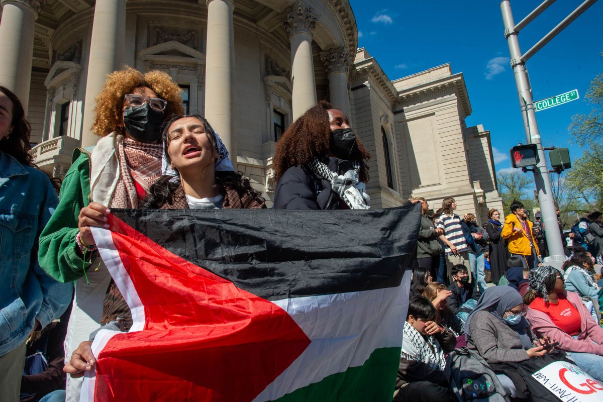 Yale students and protesters sing and rally chants as they block the intersection of College Street and Grove Street, outside Woolsey Hall, in New Haven, Conn., on April 22, 2024.