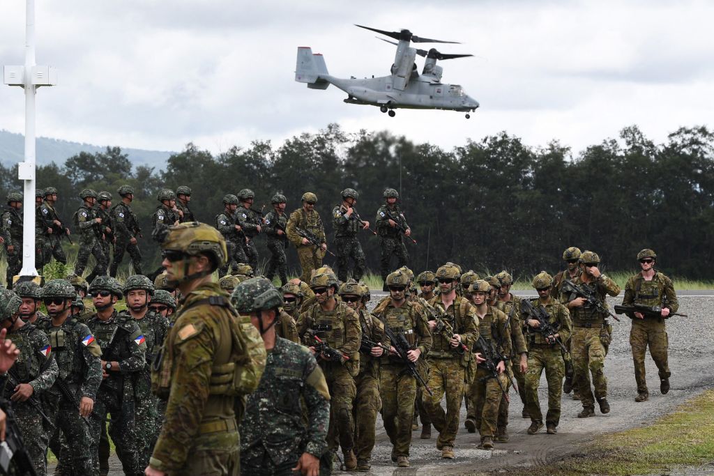 Tentara Filipina dan Australia berbaris dalam formasi sementara US marines V-22 Osprey melayang di atas selama latihan militer Alon, latihan pendaratan amfibi gabungan yang diadakan di pangkalan Angkatan Laut di kota San Antonio di provinsi Zambales, di utara Manila pada 25 Agustus 2023.