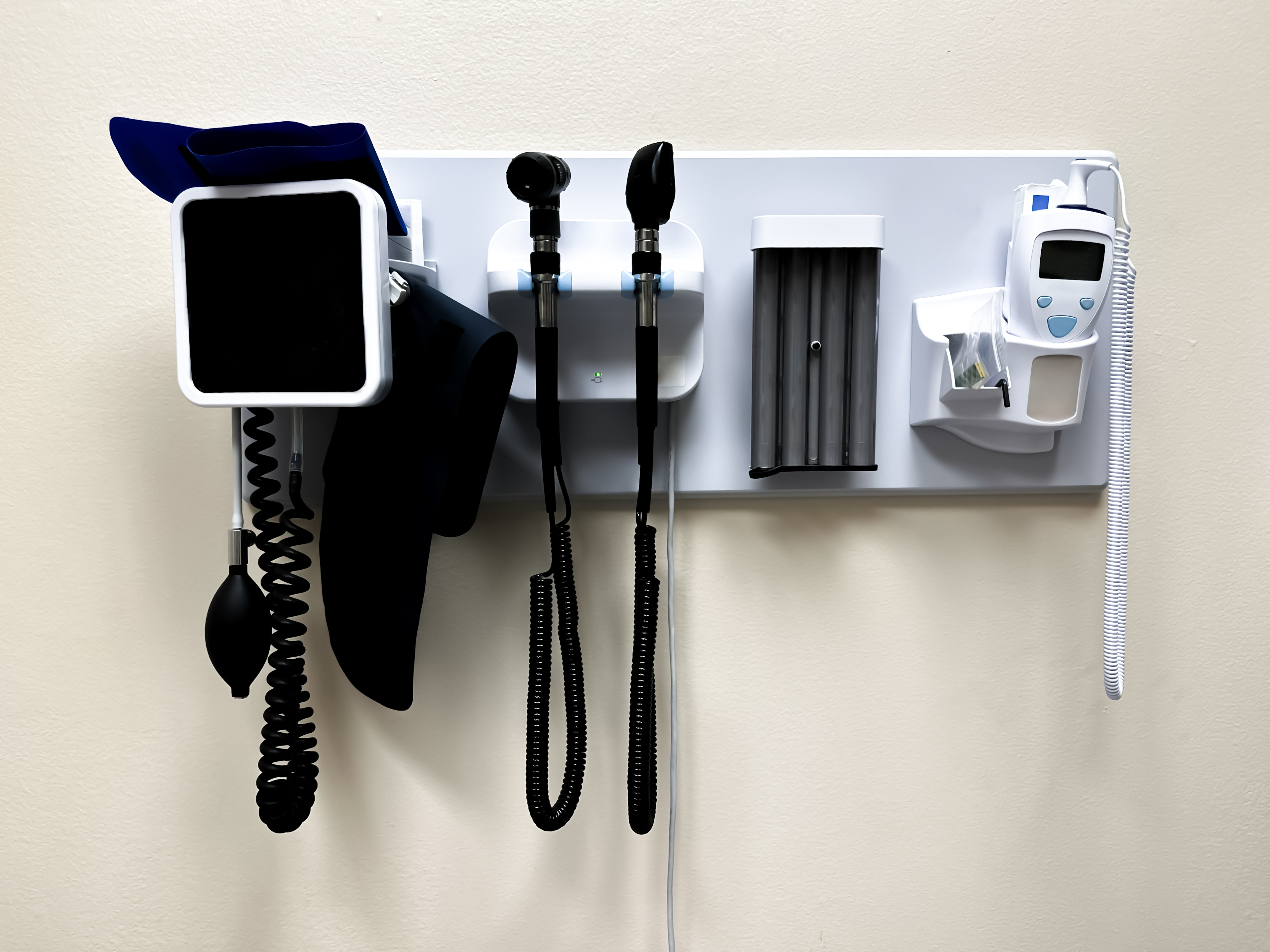 wall-mounted panel of medical diagnostic equipment in standard patient examination room