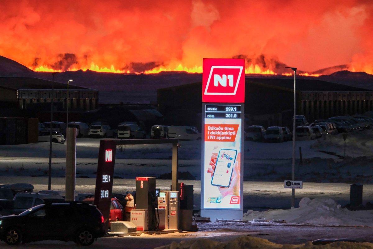 人們在火山噴發時在加索林站加滿他們的車輛，火山噴發時熔岩和滾滾濃煙從 Grindavík 附近的裂縫中噴出