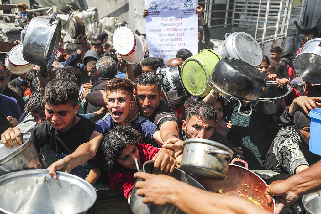Displaced Palestinians queue for hot meals amid worsening crisis in Gaza