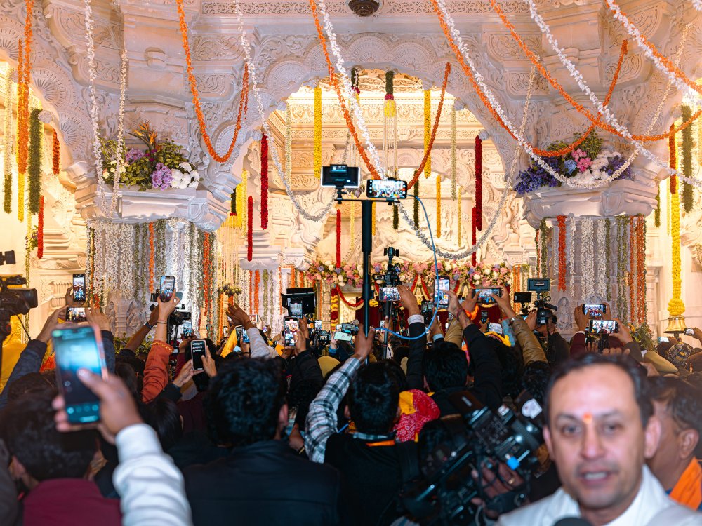 Penganut bersorak, beribadat dan sujud di hadapan salah satu skrin LCD yang banyak yang ditempatkan di seluruh bandar Ayodhya menayangkan siaran langsung upacara pengukuhan kuil Ram pada 22 Januari. Siaran langsung yang sama juga ditayangkan di Times Square di New York dan bahagian lain di dunia.