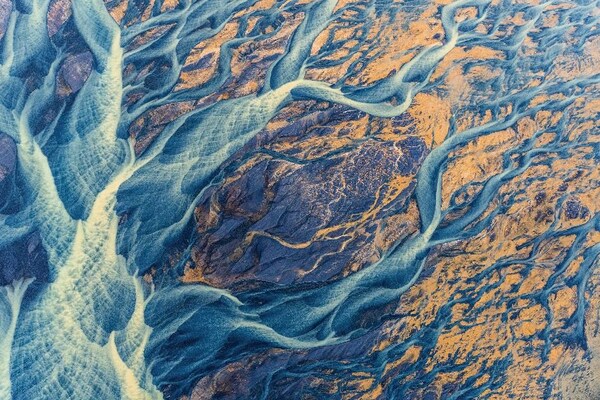 JUARA PERTAMA: AIR Sedimen berwarna-warni cerah melukis lanskap Islandia saat mengalir menuju lautan. Sungai glasial, Þjórsá, adalah sungai terpanjang di Islandia. © Kristin Wright/ Kontes Foto TNC 2022