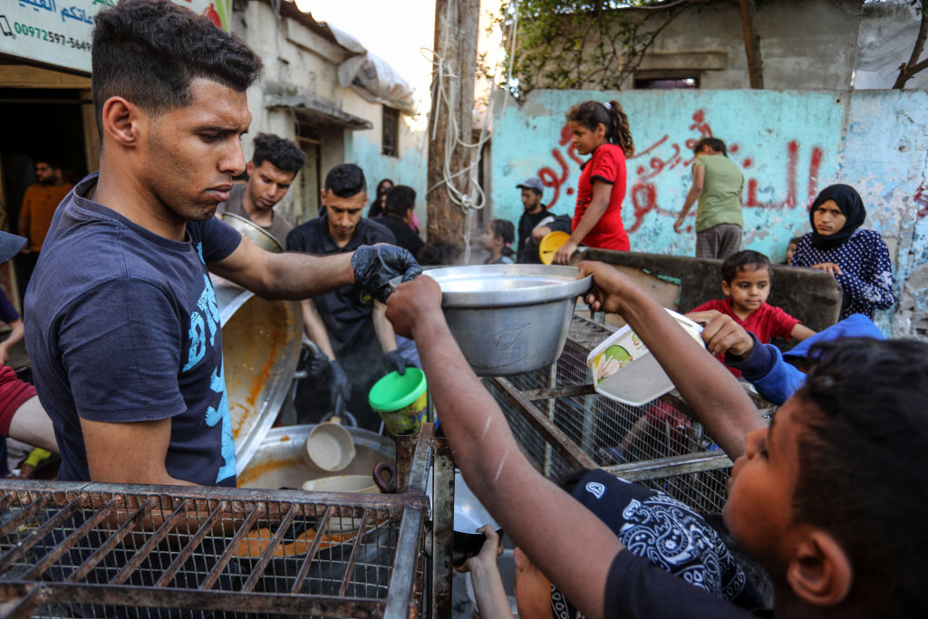 Palestinians in Gaza queue for hot food