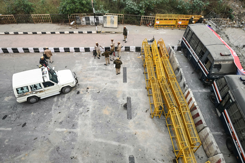 Sicherheitspersonal steht während eines landesweiten Streiks der Bauern an einer Straßensperre entlang der Grenze zwischen Ghazipur, Neu-Delhi und dem Bundesstaat Uttar Pradesh am 13. Februar 2024 Wache. 