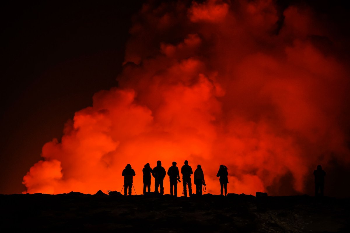Menschen betrachten den ausbrechenden Vulkan nördlich von Grindavík, Island, am 8. Februar 2024.