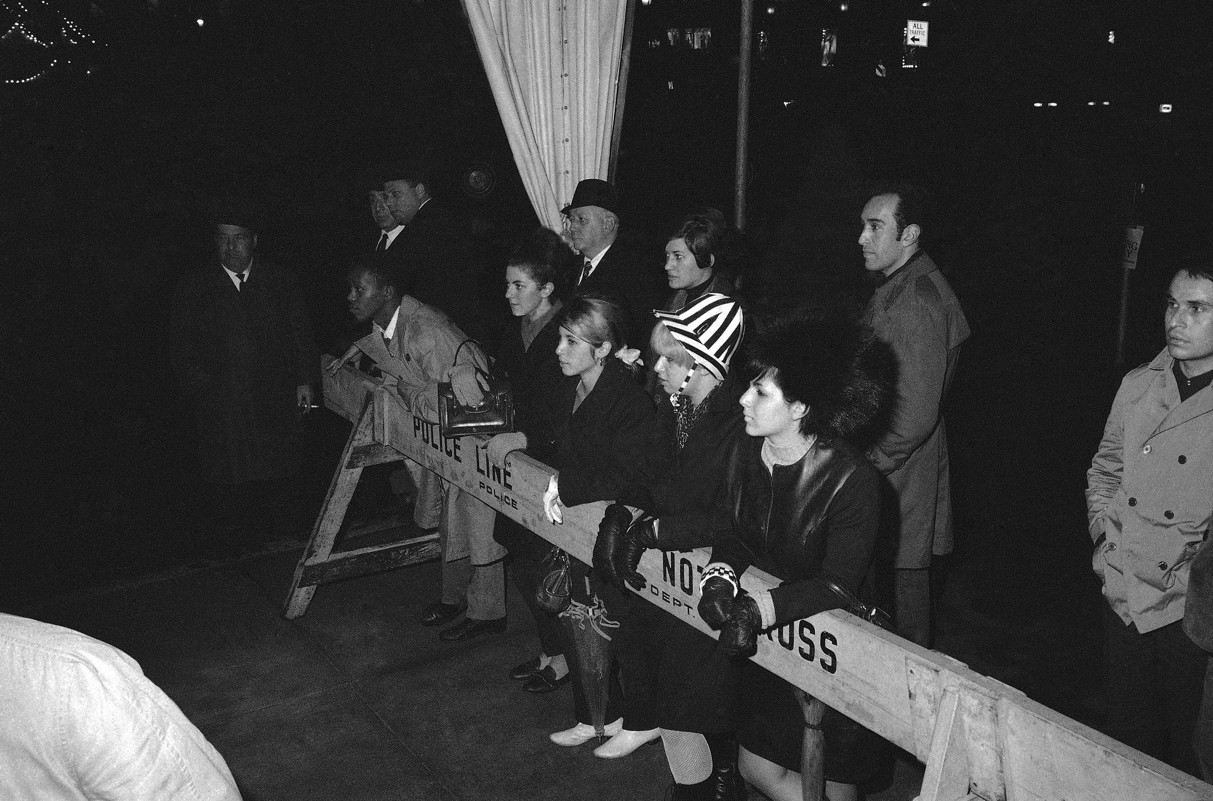 Reporter umlagern Frank Sinatra und Mia Farrow bei ihrer Ankunft auf Truman Capotes Ball in Schwarzweiß.