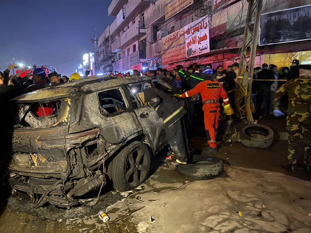 Zivile-Verteidungsangehörige versammeln sich am Anschlagsort eines durch eine von den Vereinigten Staaten durchgeführte Drohnenattacke zerstörten Fahrzeugs im Osten Bagdads, Irak, Mittwoch, 7. Februar 2024.