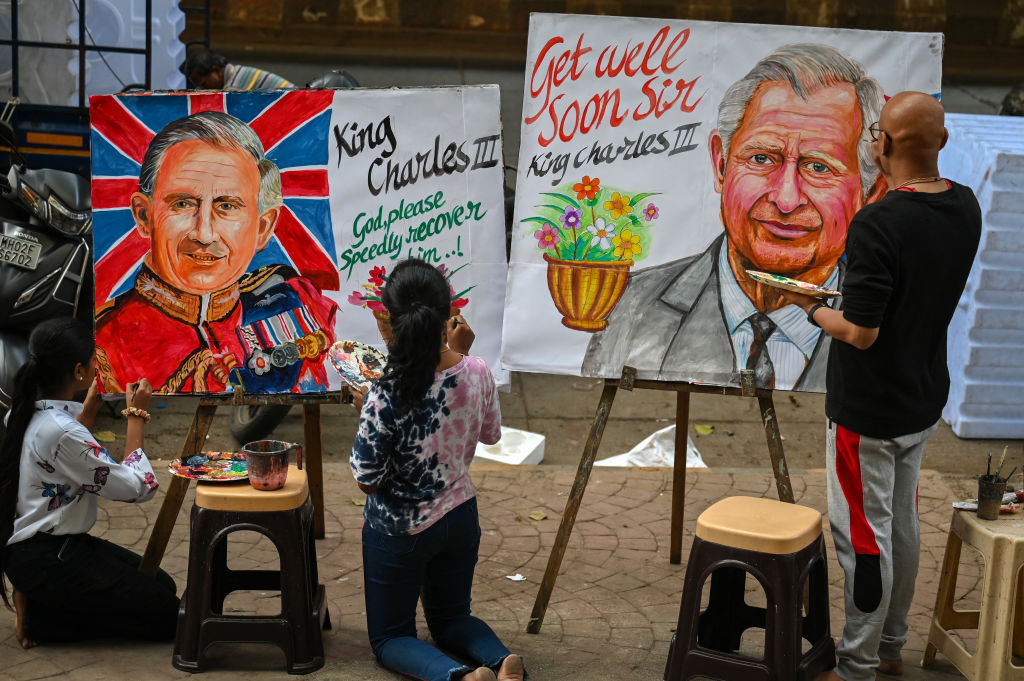 Ein Künstler (R) und Studenten geben den letzten Schliff an Gemälden von König Charles III. von Großbritannien, um ihm eine schnelle Genesung zu wünschen, vor einer Kunstschule in Mumbai.